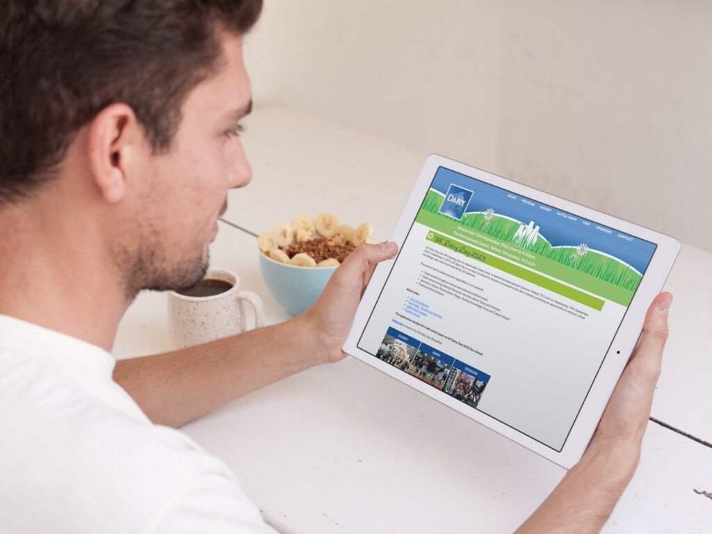 Farmer looks at Dairy Day expo website on his iPad while eating breakfast